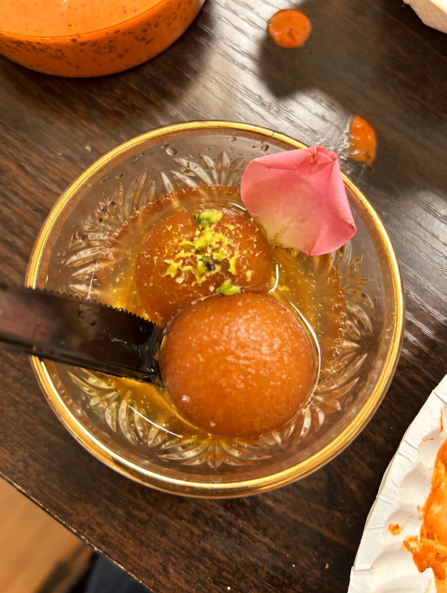 Classic Gulab Jamun dessert from New Delhi Indian Restaurant: two soft milk dumplings in warm saffron-cardamom syrup